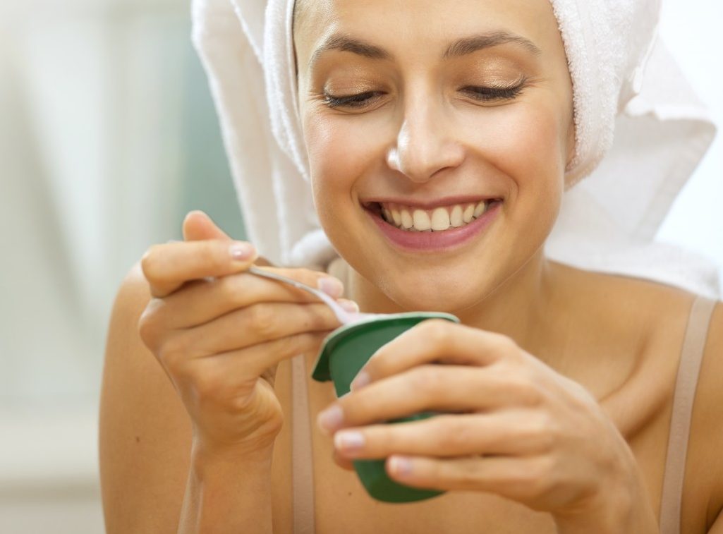 Woman eating yogurt --- Image by © Adrianko/Corbis