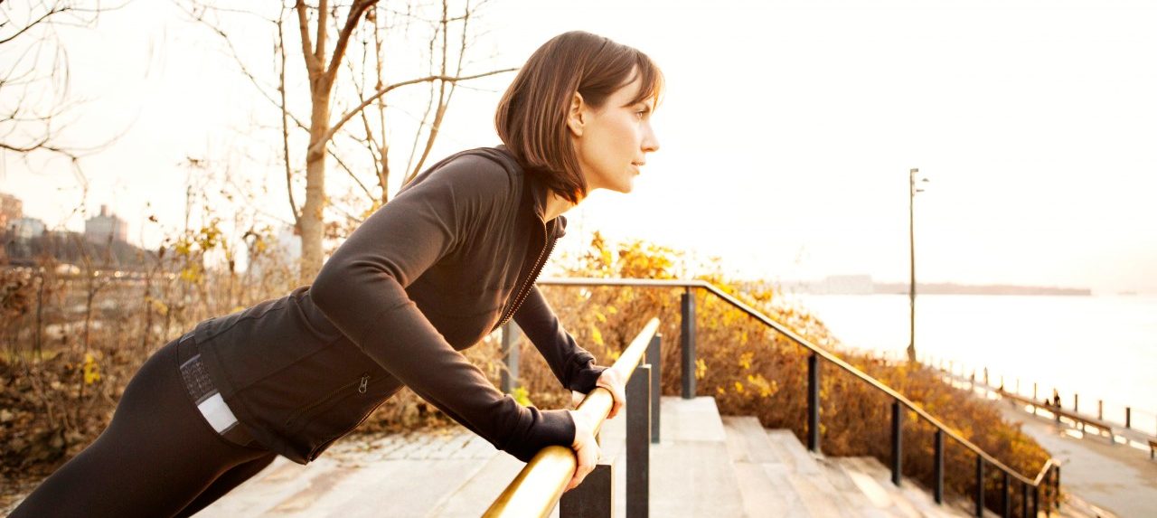 0042-11-30T00:00:00.000Z 04 Dec 2012 --- Female runner working out on park railing --- Image by © Cavan Images/Corbis
