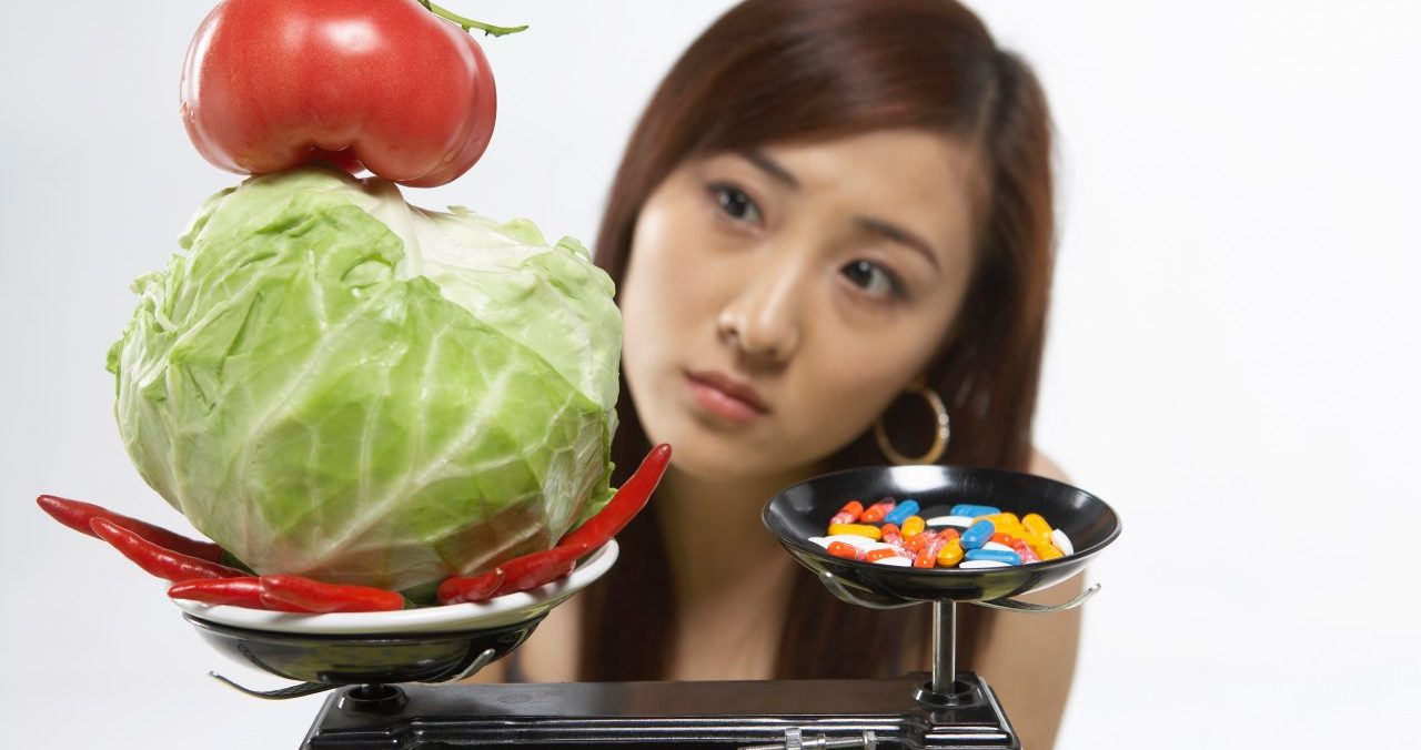 Young Woman With Healthy Food And Pills On Scales --- Image by © Blue Jean Images/Corbis