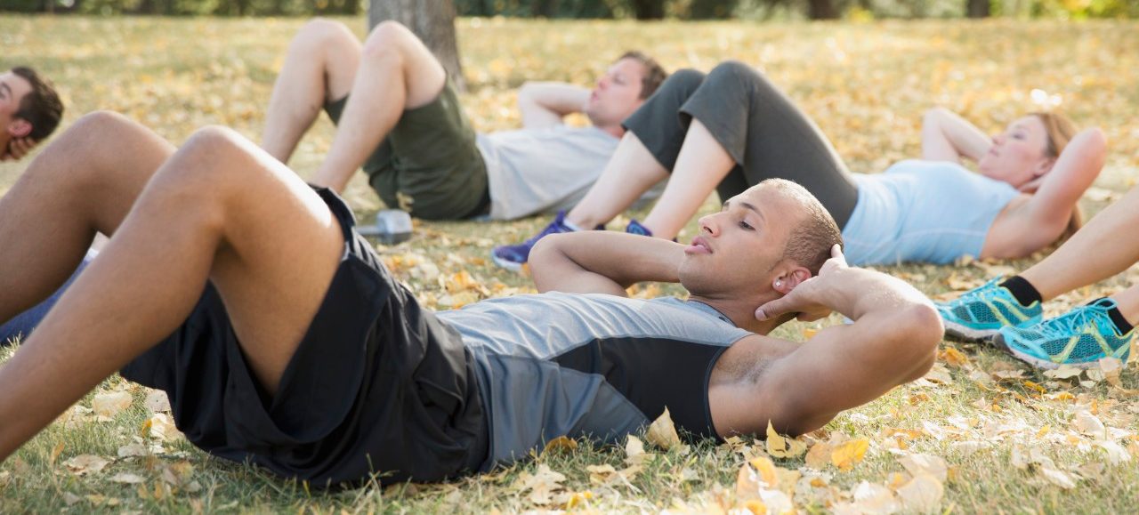 19 Sep 2012 --- Bootcamp class doing sit-ups outdoors. --- Image by © Hero Images/Corbis
