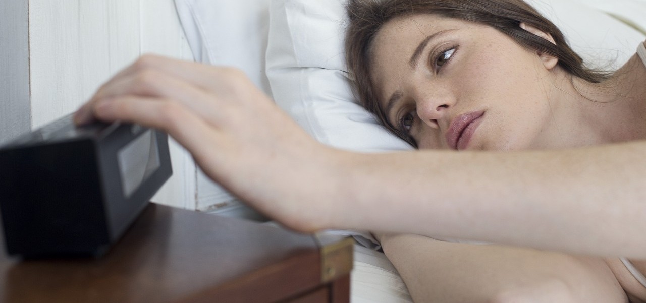 18 Feb 2014 --- Woman in bed pressing alarm clock snooze button --- Image by Â© Frederic Cirou/PhotoAlto/Corbis