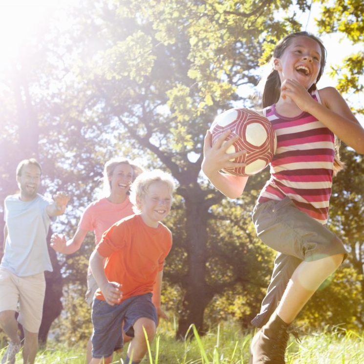 16 Sep 2014 --- Grandparents and grandchildren running with ball in rural field --- Image by © Ian Lishman/Juice Images/Corbis